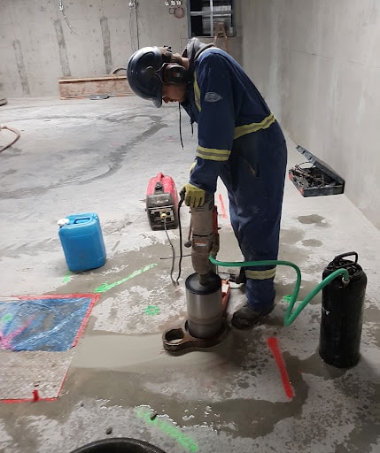 RLW technician performing concrete core drilling on slab